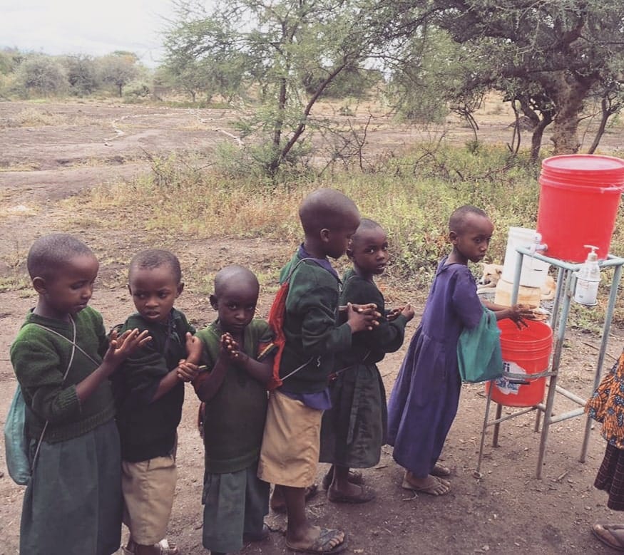 Children washing hands at clean water station